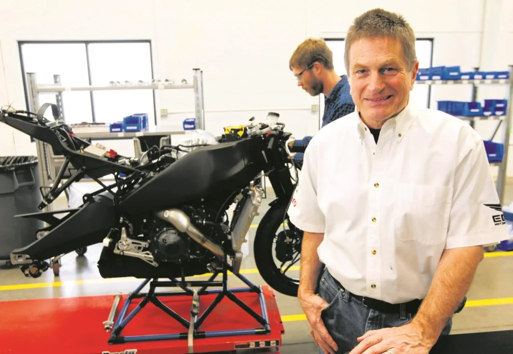 Ingeniero junto a una moto deportiva en desarrollo dentro de un taller