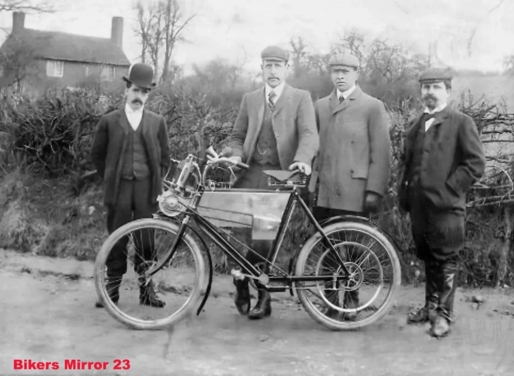 Foto antigua de cuatro hombres junto a una de las primeras motocicletas Royal Enfield